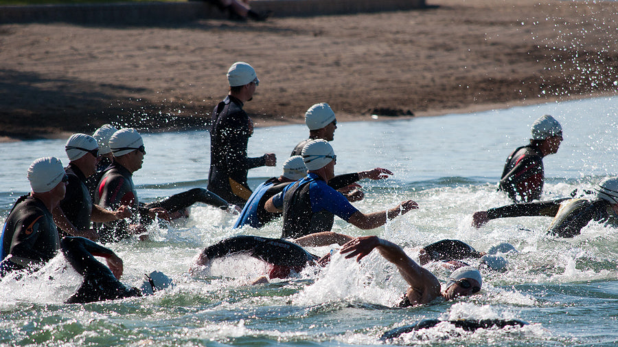 triathlon participants in cold water swim wear