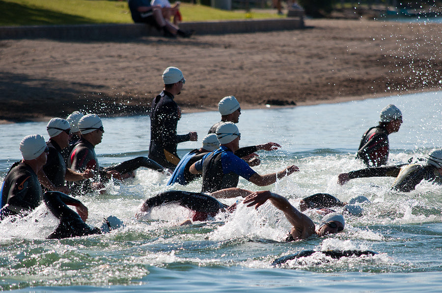 triathlon participants in cold water swim wear