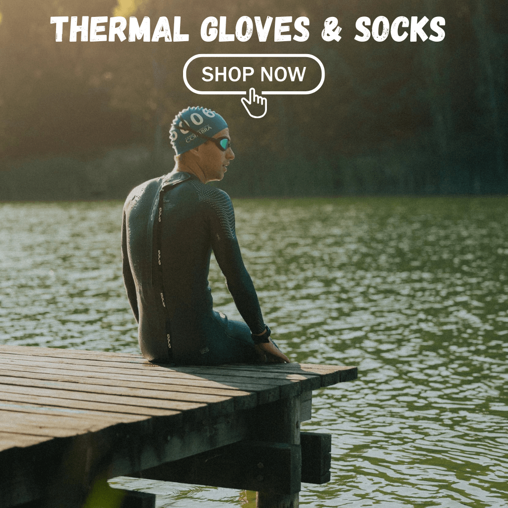 An open water swimmer sits on a pontoon at a lake wearing his wetsuit and neoprene accessories 