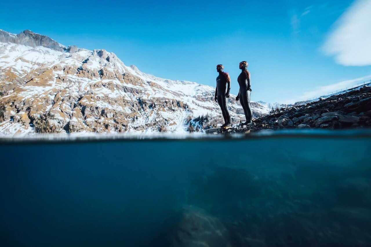 Two cold water swimmers wearing their Orca wetsuits ready to sea swim. 