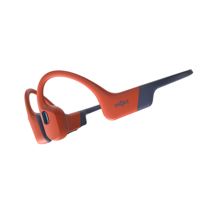 A pair of orange and gray OpenSwim Pro bone conduction headphones by Shokz, designed for open-water swimming and other sports.