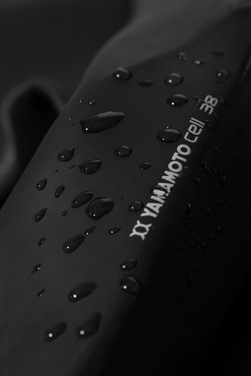 Open water swimming wetsuit leg detail showing yamamoto neoprene logo with water droplets. 