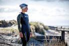 An open water swimmer approaches the water in her explorer ultra wet suit before a sea swim. 